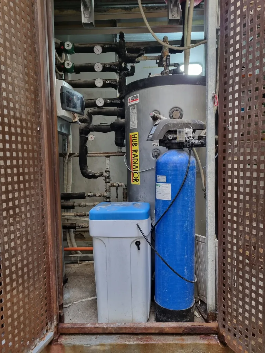 Addolcitore installato in una centrale termica, accanto al bollitore e ai collettori