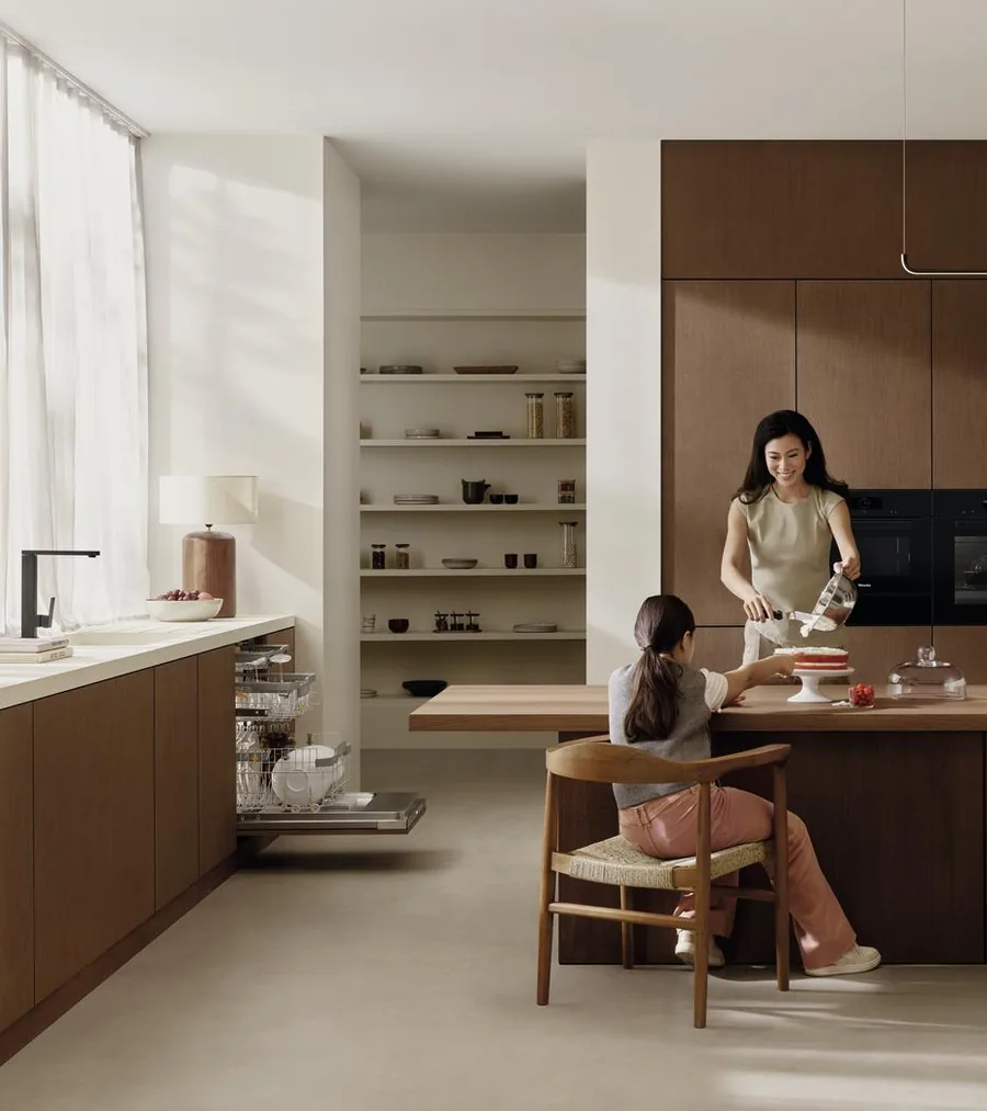 Cucina con lavastoviglie Miele aperta, madre e figlia a tavola