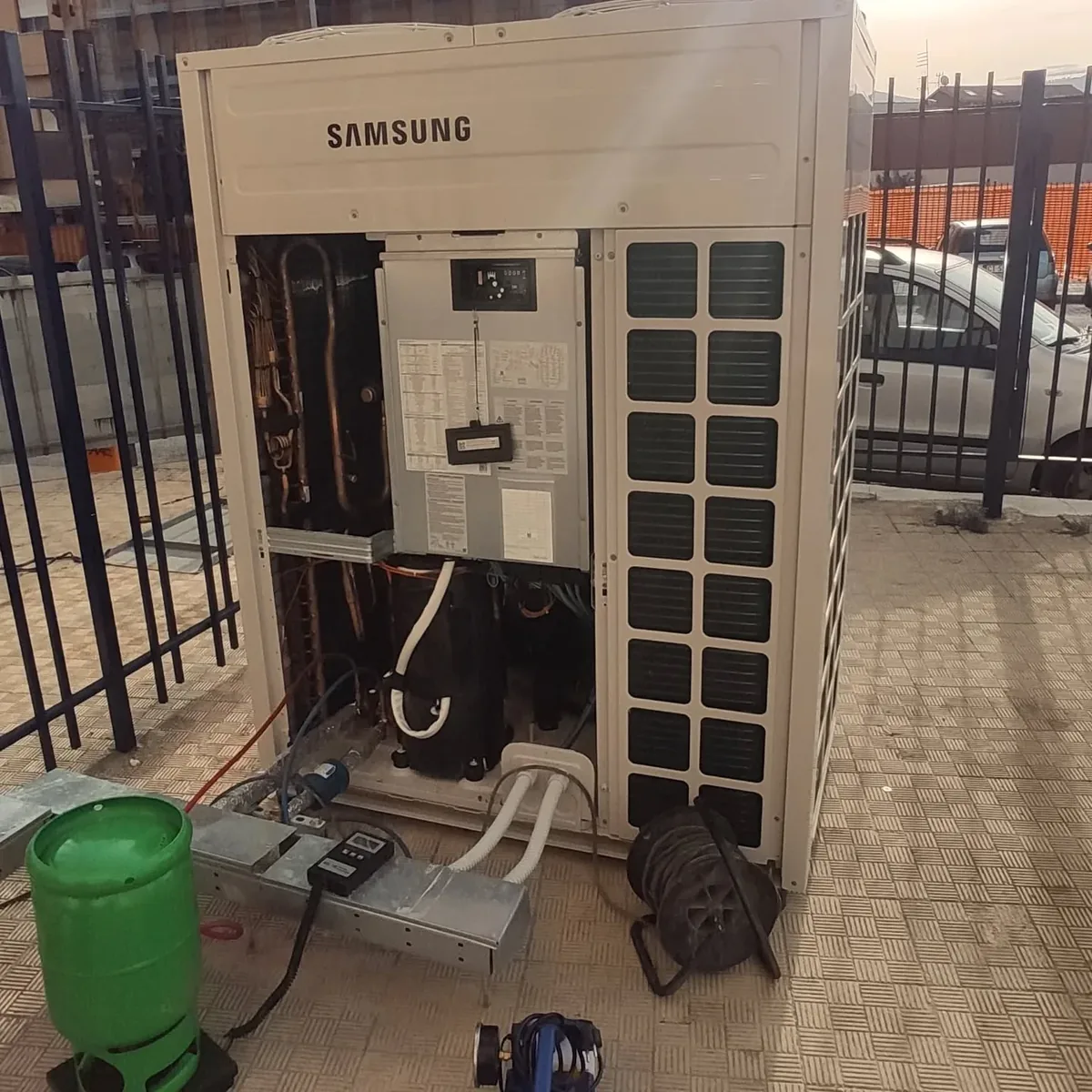Unità esterna Samsung DVM aperta durante un intervento, con bombola di recupero del refrigerante