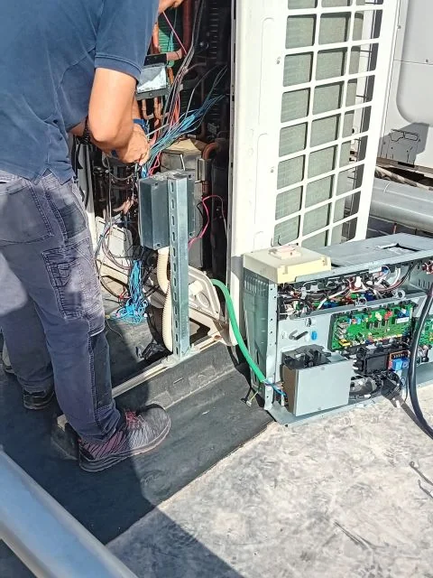Tecnico al lavoro su un'unità esterna aperta, in copertura